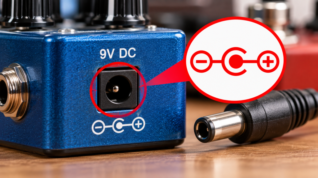 Close-up of the centre-negative polarity symbol to check to avoid using the wrong 9v adapter on a guitar pedal.